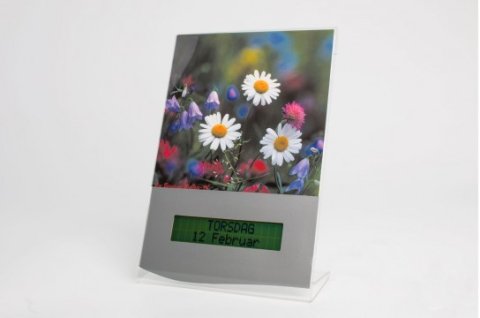 An image of white, purple, and pink flowers above a digital display featuring the day of the week, month, and date.