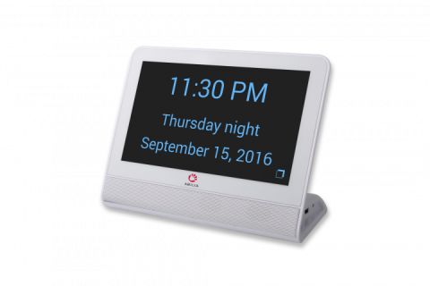 A white rectangular device with a black background and large blue text displaying the time, day, time of day, and date.