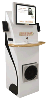 A tall, white terminal with a monitor and speakers at the top, a tray in the middle, and a speaker near the bottom.