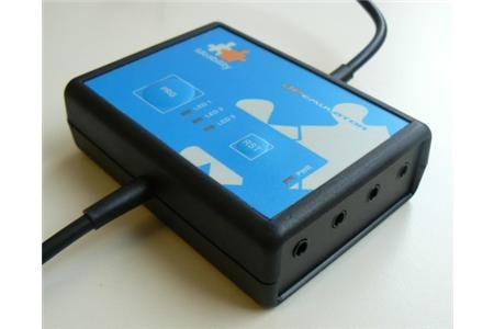 A black rectangular box that has four inputs for joysticks on shorter end and wires protrude from both longer ends.
