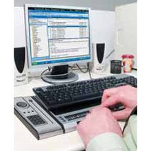 COBRA 11 being used on a desktop computer. The user has a keyboard on top of the braille display.