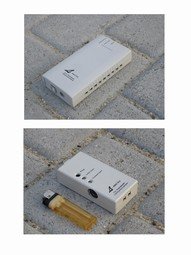 A small, rectangular device slightly larger than a lighter with ports on the sides.