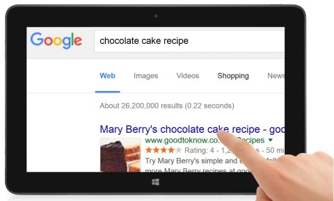 Tablet computer with a finger touching the screen, which is magnifying Google search results.