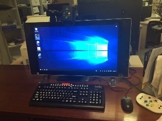 Monitor and wireless keyboard and mouse. Monitor has a camera mounted by an arm extending from top of monitor.