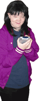 Woman wearing a jacket and looking at a handheld device in her hand.