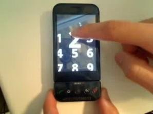 A small, black smartphone with a number of dial-pad that is shown magnified on the screen. A user is dialing the number "2."