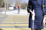A person walking down a street with a white that has a long handle with menu options.