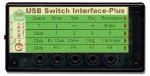 Rectangular black device with USB Switch Interface table noting controls. Switch inputs along bottom edge of device.