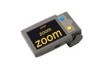 Medium-sized grey device with a rectangular screen with a black background that says the word "zoom" in high-contrast yellow font. To the right of the screen, there are two round menu buttons, one blue and one yellow. 