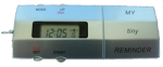 Small, long, and silver device with a small LCD panel displaying the time. The device features various small menu buttons. On the right-hand side, the device reads "My tiny reminder."