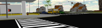 Long, horizontal image of a street intersection, with marked pedestrian crossing lines in the middle.