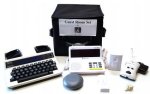 The full range of components in the kit, including a round smoke detector, a TTY with built-in keyboard, and other components.