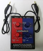 Small rectangular device with two TSR connector cables and four controls knobs, two red and two blue.