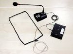 Image of a large rectangular wire loop connected to a goose-neck microphone and base next to a small black device.