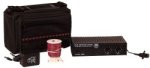 A black travel case shown next to a medium-sized, black, and rectangular device, with a spool of cord, and other electrical components.